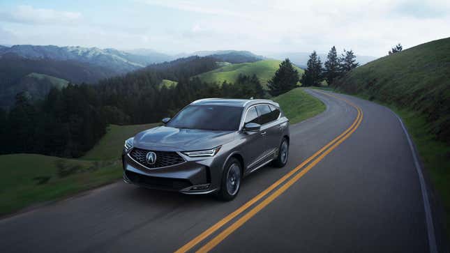 A gray MDX driving on a mountain road