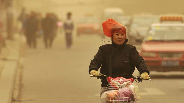 A woman wears a plastic bag over her head in Shanxi province.