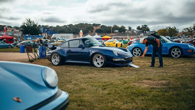 A dark blue Porsche 993-generation 911 GT2 is parked on grass