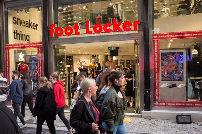 People are passing in front of a Foot Locker store at Ermou street in the center of Athens, Greece. 