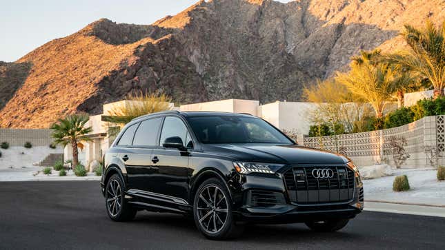 A black Audi Q7 parked in Palm Springs in front of a midcentury modern house and the mountains