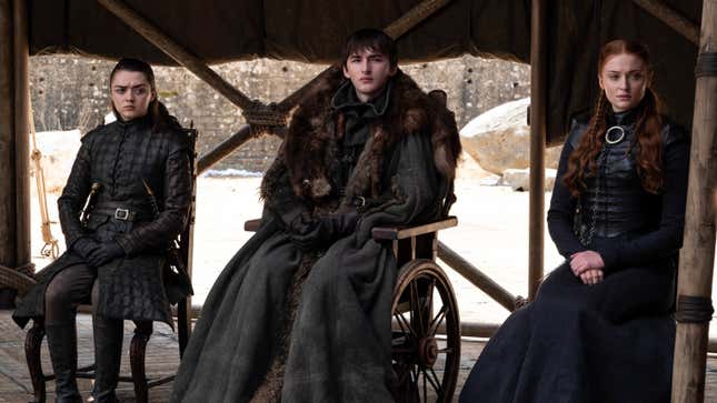 The black-clad Arya, Bran, and Sansa Stark sit stone-faced on a covered dais in the Dragonpit.