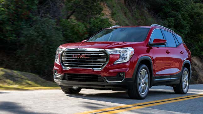 Un GMC Terrain rouge conduisant sur une route de montagne