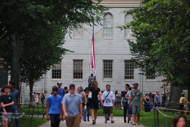 Visitors walk through the Yard near the John Harvard Statue at Harvard University in Cambridge, Massachusetts, U.S., July 6, 2023.