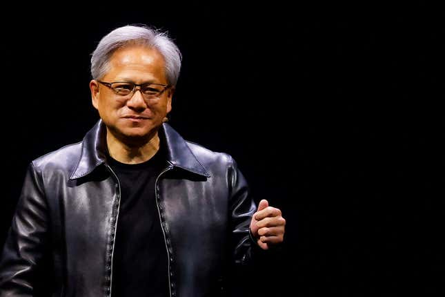 Jensen Huang wearing a black shirt and black leather jacket standing in front of a black background
