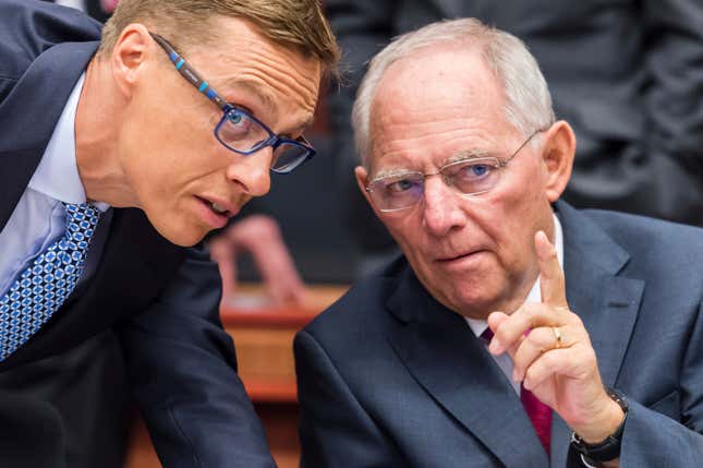 FILE - German Finance Minister Wolfgang Schaeuble, right, talks with Finnish Finance Minister Alexander Stubb during a meeting of eurogroup finance ministers at the EU Council building in Brussels on Monday, July 13, 2015. Wolfgang Schaeuble, who helped negotiate German reunification in 1990 and as finance minister was a central figure in the austerity-heavy effort to drag Europe out of its debt crisis more than two decades later, has died on Tuesday, Dec. 26, 2023. He was 81. (AP Photo/Geert Vanden Wijngaert, File)