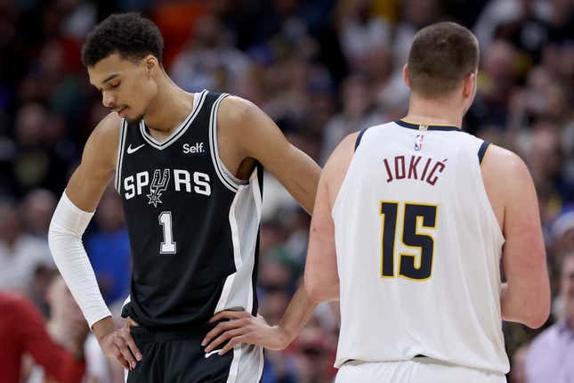 DENVER, COLORADO - APRIL 02: Victor Wembanyama #1 of the San Antonio Spurs and Nikola Jokic #15 of the Denver Nuggets pass on the court during the fourth quarter at Ball Arena on April 02, 2024 in Denver, Colorado. NOTE TO USER: User expressly acknowledges and agrees that, by downloading and or using this photograph, User is consenting to the terms and conditions of the Getty Images License Agreement. (Photo by Matthew Stockman/Getty Images)