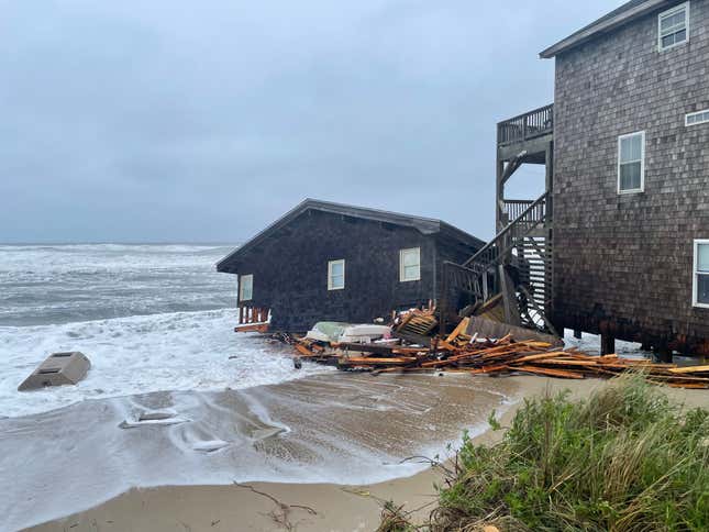 A collapsed wooden house in the surf.