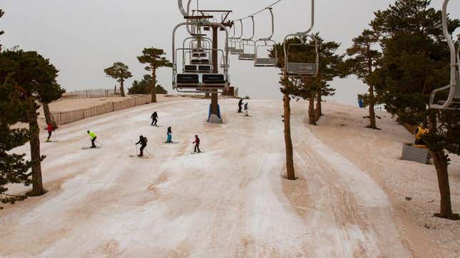 People ski at the Navacerrada ski resort on March 16, 2022, in Madrid, Spain on the second consecutive day a reddish blanket of dust has hovered over the country. 