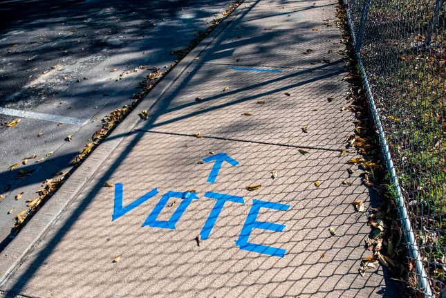 A sidewalk is shown with “Vote” written in tape outside a polling location on election day in Austin, Texas on November 3, 2020