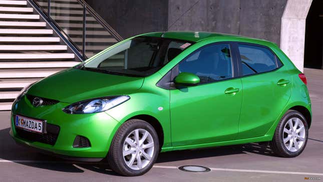 A photo of a green Mazda 2 hatchback. 