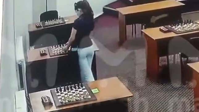 A screenshot shows a woman near a chess board. 