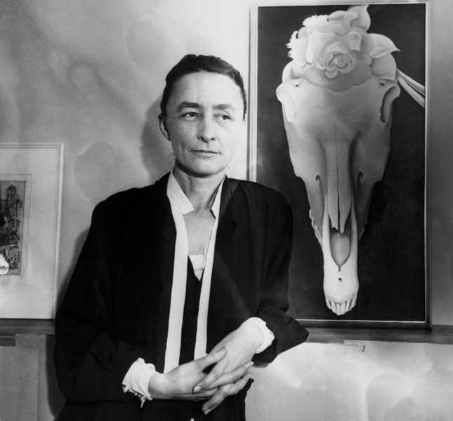 Artist Georgia O'Keeffe stands next to her painting Horse Skull with White Rose at an exhibit of her work titled Life and Death.