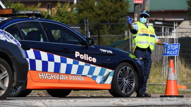 A police officer holds a sign to stop traffic at a compliance road block in the suburb of Guildford on August 19, 2021 in Sydney, Australia. Judges told ABC that the rise in Sovereign Citizen tactics began during the COVID-19 lockdowns.