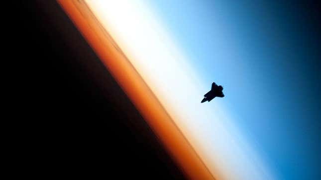 The Space Shuttle Endeavor pictured against Earth’s atmosphere, with the stratosphere appearing as a white layer.