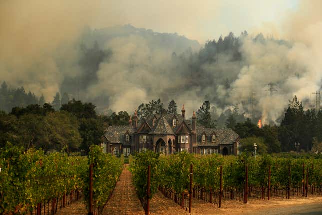 FILE - A wildfire burns behind a winery Saturday, Oct. 14, 2017, in Santa Rosa, Calif. The U.S. West Coast produces over 90% of America&#39;s wine, but the region is also prone to wildfires — a combustible combination that spelled disaster for the wine industry in 2020 and one that scientists are scrambling to neutralize. (AP Photo/Jae C. Hong)