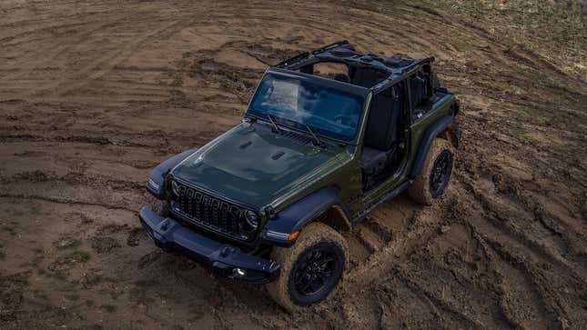 Une photo d’une Jeep Wrangler vert foncé conduisant hors route. 