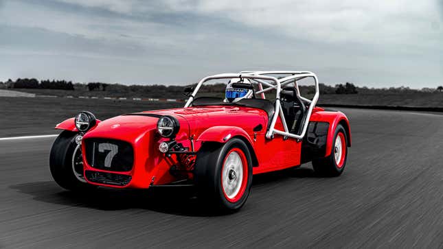 A photo of a bright red Caterham two-seater sports car with a white roll cage. 