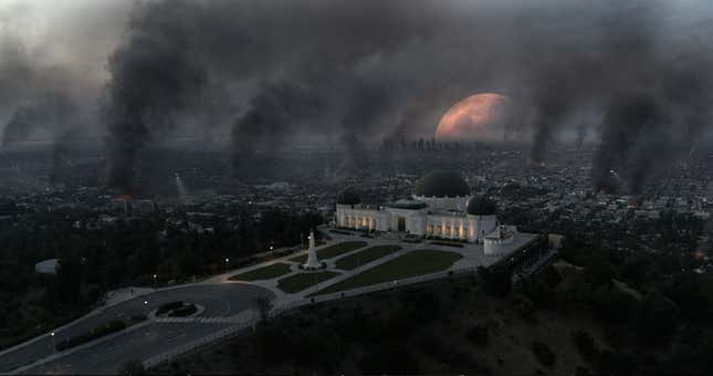 The moon falls to the Earth in the background as Los Angeles looms in the foreground in this scene from Moonfall.