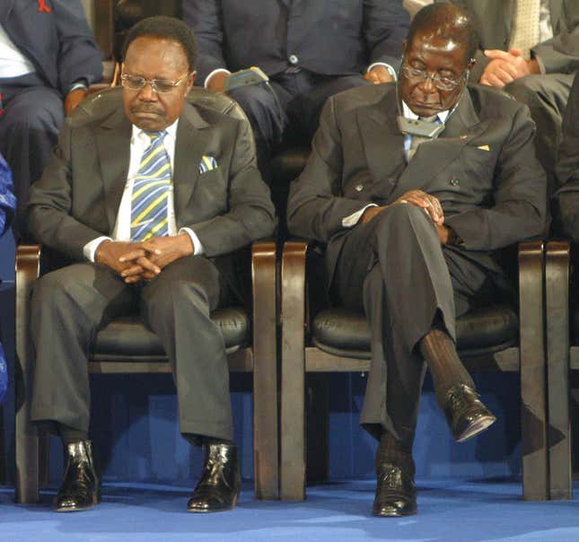 Gabon's President Omar Bongo (L) sits beside Zimbabwe's President Robert Mugabe during the opening ceremony of the Africa-France summit in Bamako, Mali December 3, 2005. French President Jacques Chirac told African leaders on Saturday that rich nations must find more innovative ways to fund development in the world's poorest continent and pledged that France would champion their cause.