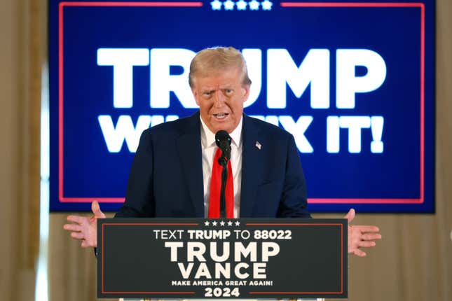 El presidente electo Donald Trump habla en un podio frente a carteles de Trump y Vance