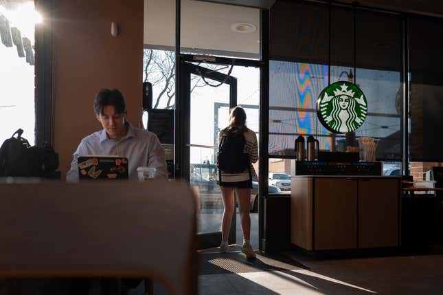 Un client est assis, tandis qu’un autre sort, dans un Starbucks à Chicago, dans l’Illinois.