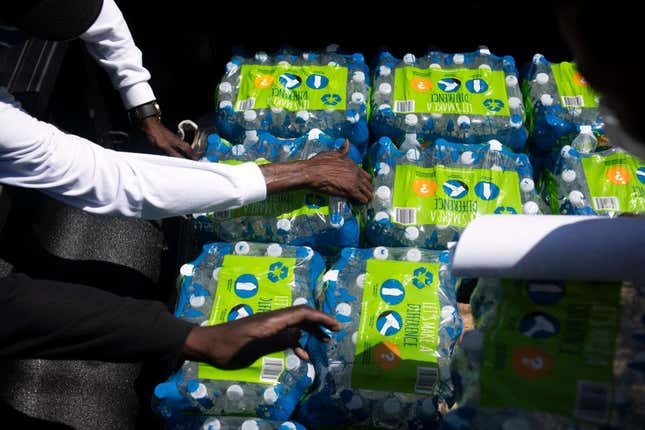 Members of Operation Good grab cases of water to hand out in Jackson, Mississippi, on March 24, 2022. - Every morning, 180 students at a school in Jackson, Mississippi, must board a bus to be taken to another nearby school. The reason? Their school lacks the water pressure needed to flush its toilets. Cheryl Brown, the principal at Wilkins Elementary, where 98 percent of the 400 students are African-American, and most come from underprivileged backgrounds, doesn’t hide her frustration. 