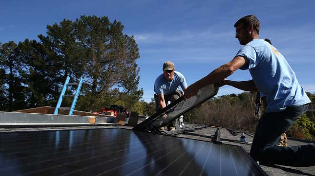 SolarCraft workers Joel Overly (L) and Craig Powell (R) install a solar panel on the roof of a home on February 26, 2015 in San Rafael, California. 