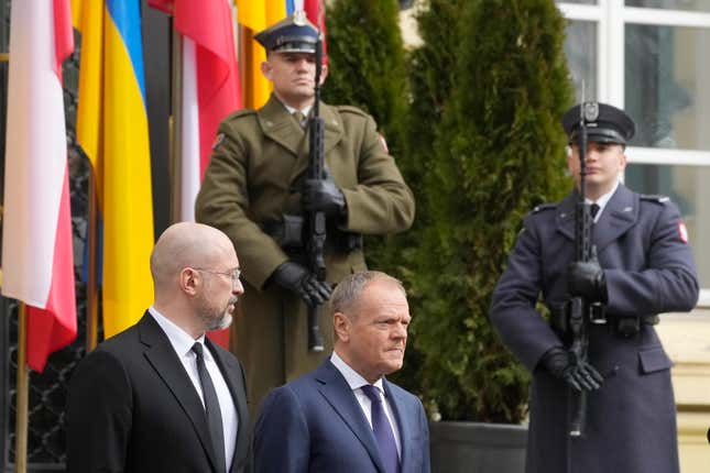 Ukrainian Prime Minister Denys Shmyhal, left, and his Polish counterpart, Prime Minister Donald Tusk, center, review troops during a welcoming ceremony ahead of their talks in Warsaw, Poland, Thursday March 28, 2024. (AP Photo/Czarek Sokolowski)