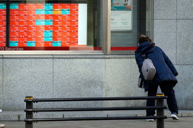 FILE - A person looks at an electronic stock board showing Japan&#39;s Nikkei 225 index at a securities firm in Tokyo, on Jan. 17, 2024. Asian shares traded mixed Thursday, Jan. 18, 2024 as pessimism spread among investors about any imminent interest rate cut in the United States. (AP Photo/Eugene Hoshiko, File)