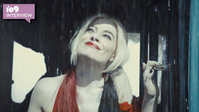 Margot Robbie's Harley Quinn looks up and appreciates the rain while wearing a bright red dress.
