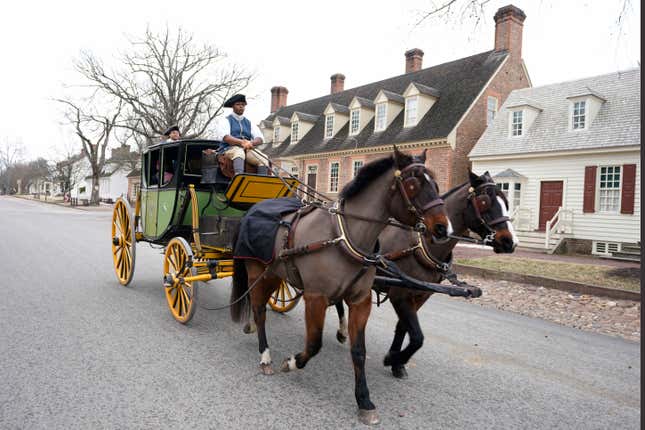 Colonial Williamsburg coachman Collin Ashe drives a coach full of visitors down Duke of Gloucester Street in the restored area Thursday Feb. 24, 2022, in Williamsburg, Va. Colonial Williamsburg has begun to honor the coachmen by naming a new carriage after one of them.