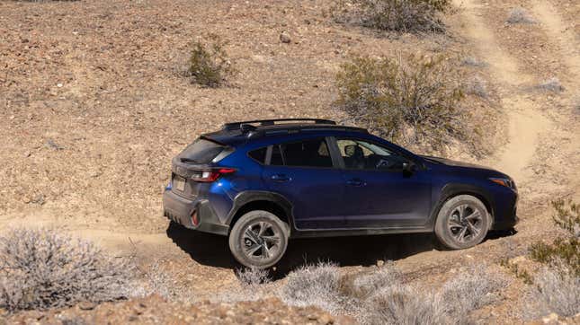 A blue Subaru Crosstrek off-roading in the desert