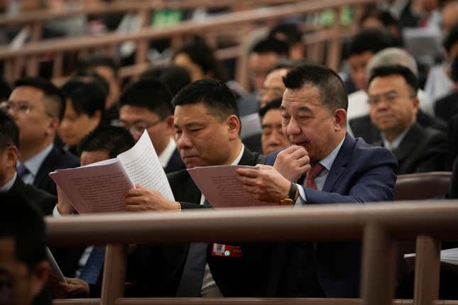 Delegates read the opening remark by Chinese Premier Li Qiang during the opening session of the National People&#39;s Congress (NPC) at the Great Hall of the People in Beijing, China, Tuesday, March 5, 2024. (AP Photo/Andy Wong)