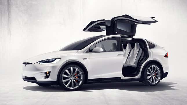 A photo of a white Tesla Model X with its doors open. 