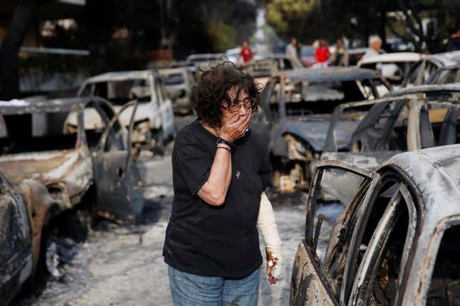 A woman reacts as she tries to find her dog in the village of Mati, near Athens.
