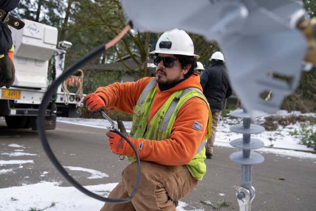 File - A worker from Portland General Electric replaces a power line as crews work to restore power after a storm on Jan. 16, 2024, in Lake Oswego, Ore. On Friday, Feb. 2, 2024, the U.S. government issues its January jobs report. (AP Photo/Jenny Kane, File)