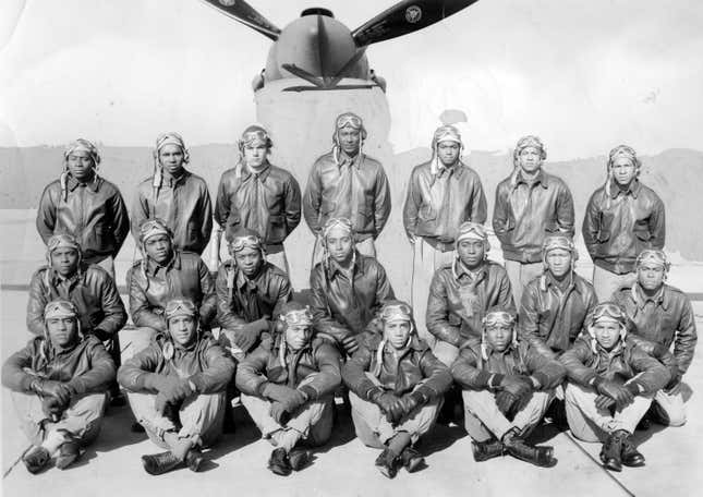 Tuskegee Airmen receiving their commissions at a parade at Tuskegee Army Airfield, with an airplane in the background, during World War 2, Tuskegee, Alabama, January 6, 1945. 