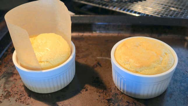 Two ramekins with soufflé pancakes inside.