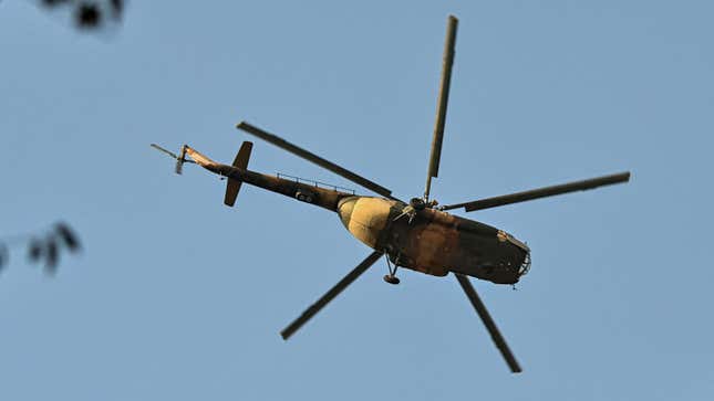 A military helicopter flies overhead