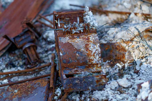 FILE - An old cash register sits among the charred remains of a home burned in the Slater Fire in Happy Camp, Calif., Oct. 6, 2021. The U.S. government has threatened to sue a unit of Warren Buffett’s Berkshire Hathaway to recover nearly $1 billion of costs related to the wildfires in 2020 in southern Oregon and northern California. The potential lawsuits were disclosed in an annual report filed by PacifiCorp’s parent company, Berkshire Hathaway Energy on Monday, Feb 26, 2024. (AP Photo/David Goldman, File)