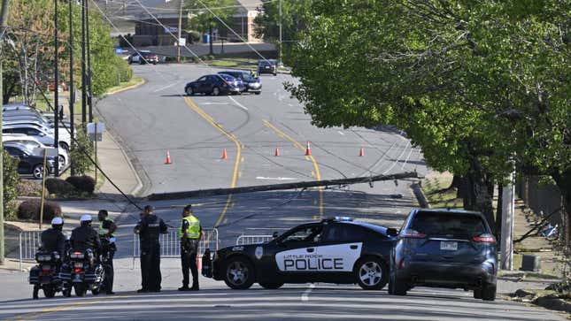 A photo of police cars and bikes at a closed road. 