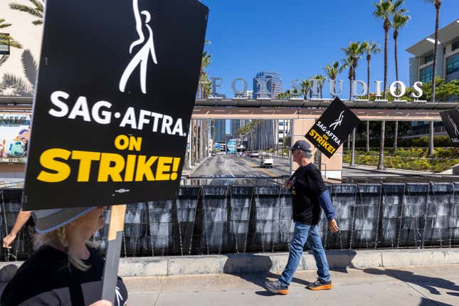 Members of the Hollywood actors SAG-AFTRA hold up signs while picketing outside Fox Studios.