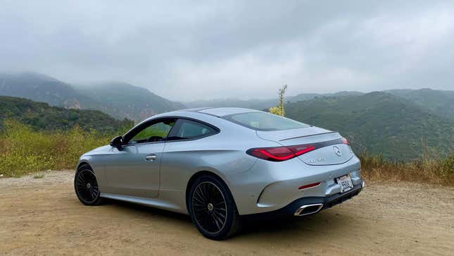 The rear 3/4 of the CLE parked on dirt in front of a cloudy mountain vista