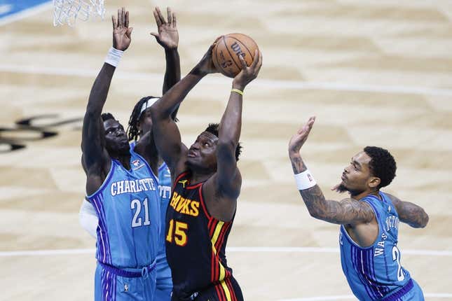 Oct 25, 2023; Charlotte, North Carolina, USA; Atlanta Hawks center Clint Capela (15) drives to the basket between Charlotte Hornets forwards JT Thor and  P.J. Washington (25) during the second quarter at Spectrum Center.