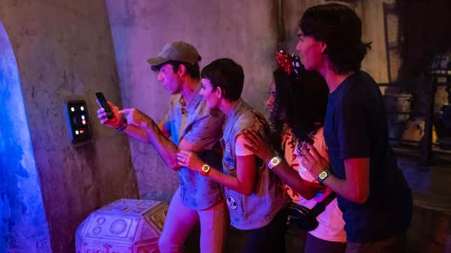 A group on their phone plays a bounty-hunting game at Star Wars: Galaxy's Edge.