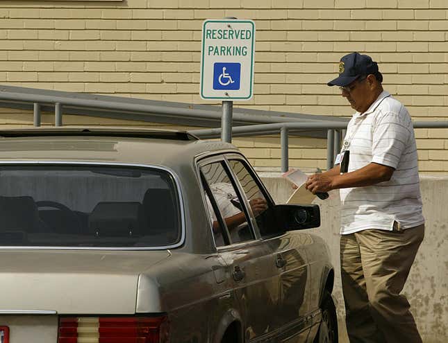 Fernando Rodriguez, agent de police, rédige une contravention pour infraction au code de la route pour personnes handicapées à l’encontre d’un véhicule stationné dans une friperie située dans le bloc 800 de Westheimer à Houston, au Texas, le 9 février 2006.