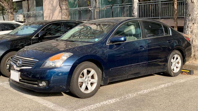 A blue Nissan Altima parked in a parking lot