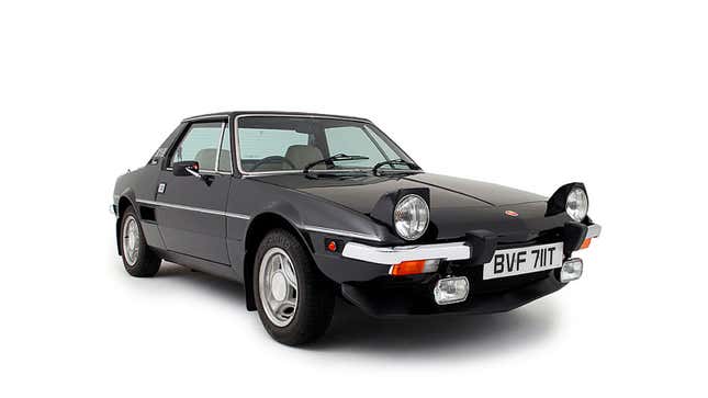 A photo of a black Fiat X1/9 sports car in a studio.