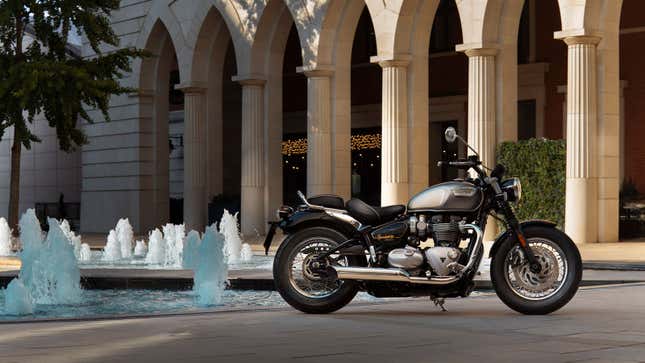 A Triumph motorbike parked by a fountain 